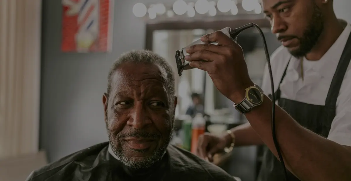 A barber working with a client in his shop.